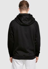Sort hoodie med snor og en rummelig hætte, lavet af blødt stof. Har ribbet kant og manchetter, samt et enkelt design.