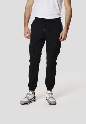 Pantalones joggers cargo negros con puños elásticos, que cuentan con múltiples bolsillos y cintura con cordón, hechos de un material ligero y flexible.