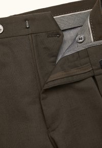 Pantaloni marrone scuro con chiusura a cerniera e bottone, con una texture liscia e una fodera grigia. Include una tasca e dettagli di cucitura.