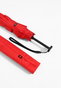 Red folding umbrella with a black metal handle, compact design, and a matching red case. Includes a strap for easy carrying.