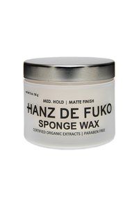 Jar en verre dépoli avec un couvercle en métal argenté, étiqueté "Hanz De Fuko Sponge Wax", comportant du texte noir, incluant "Tenue Moyenne" et "Fini Mat".