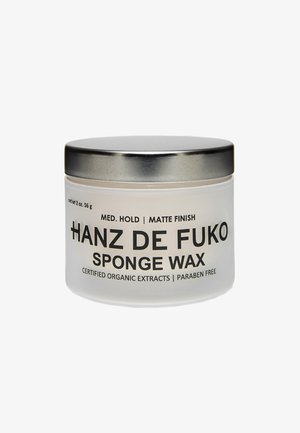Matte Glassbehälter mit silberner Metallkappe, beschriftet mit "Hanz De Fuko Sponge Wax", mit schwarzem Text, einschließlich "Mittlere Halte" und "Mattes Finish".