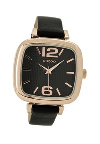 Montre carrée avec un boîtier en or rose, cadran noir texturé, grands chiffres aux positions 12 et 6, et un bracelet en cuir noir. Modèle OOZOO.