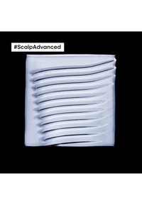 Silverfärgad kräm med slät textur, med vågiga linjer i fyrkantig form. Bakgrunden är svart och märkt med "#ScalpAdvanced."