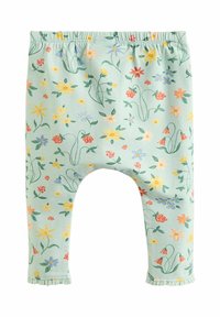 Helle grüne Leggings mit einem floralen Muster in Rot, Gelb, Blau und Grün. Elastischer Bund und Rüschen an den Knöcheln.