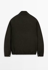 Zwarte lange mouw jas met een opstaande kraag, afgeknoopte manchetten en een elastische zoom, gezien van achteren op een effen witte achtergrond.