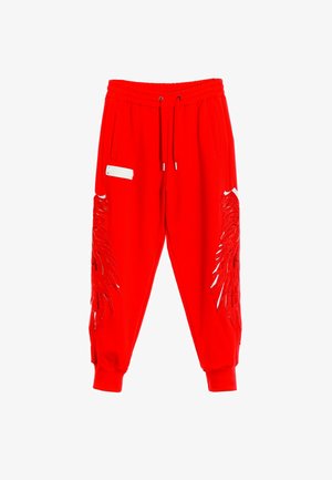 Pantalones de chándal rojos con cintura elástica y cordón ajustable; presenta recortes decorativos en forma de alas y acentos en los laterales.