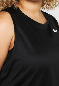 Černý bezrukávový sportovní top vyrobený z hladkého, vlhkosti odvádějícího materiálu, se zaobleným výstřihem a bílým logem.