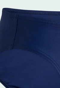 Granatowe kąpielówki z wysokim stanem wykonane z gładkiej tkaniny, z bezszwowym krojem i solidnym przeszyciem na krawędziach.