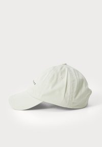 Casquette de baseball vert clair en tissu doux, avec une visière courbée et des œillets de ventilation, ornée d'un petit logo à l'avant.