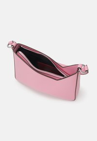 Rosa strukturert håndveske med glidelås, kontrasterende mørk kant, og et indre med svart fôr og flere lommer.