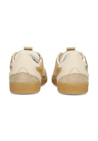Baskets beiges en cuir et daim, à bout rond, avec des accents texturés et des tirettes à l'arrière, dotées d'une semelle couleur gomme.
