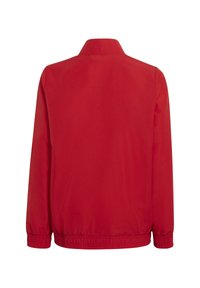 Rode jas met een ontspannen pasvorm, voorzien van een staande kraag en elastische manchetten. Gladde textuur met een effen kleur, geen zichtbare patronen of hardware.