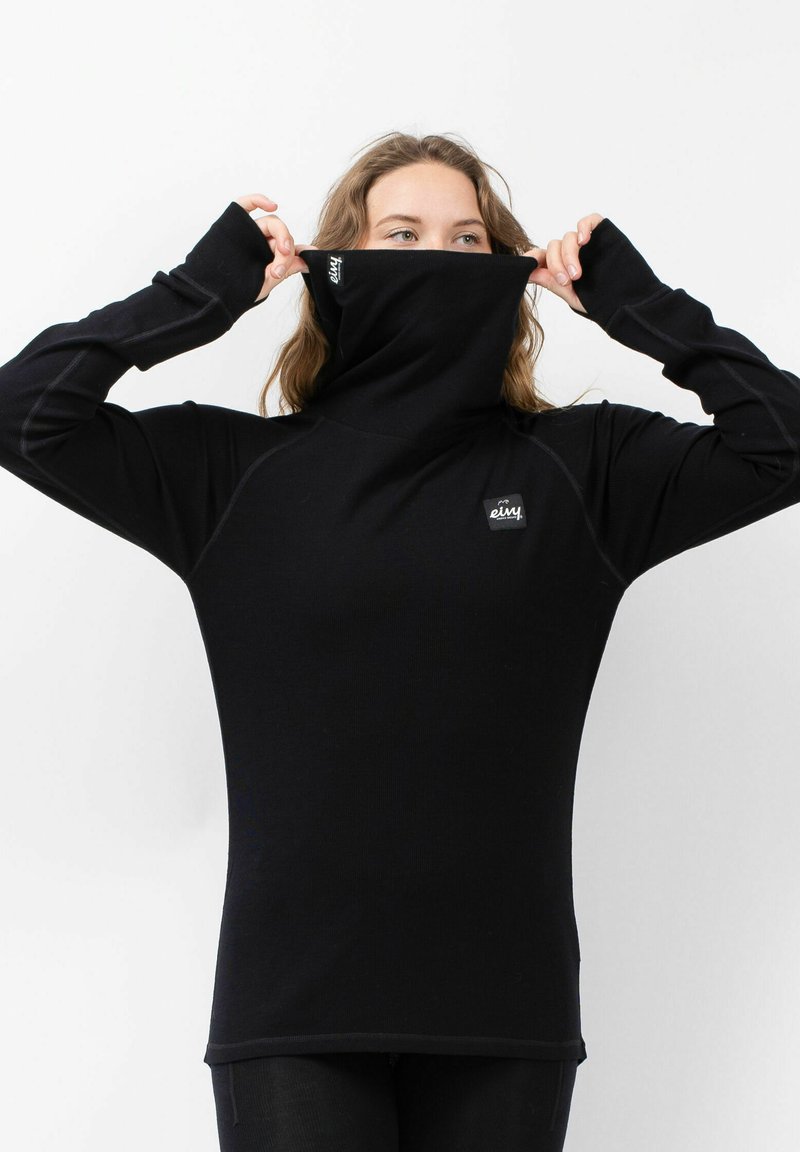 Schwarzes langärmliges Oberteil mit hohem Kragen, versehen mit einem Logo-Patch und Daumenlöchern. Hergestellt aus einem glatten, dehnbaren Stoff mit Nahtdetails.