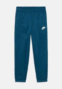 Calças de sweat da Nike em azul-turquesa com um cós elástico, pernas afinadas e logótipo branco na coxa esquerda. Tecido liso e leve.