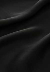 Fekete szövet, sima, matt felülettel, puha redőkkel és enyhe fénylő hatással, finom, egyenletes szövésű, minta vagy díszítés nélkül.