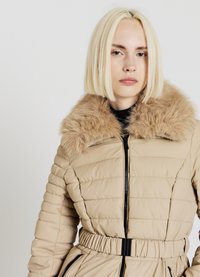 Doudoune beige à finition texturée, dotée d'un col en fausse fourrure, fermeture éclair, taille élastique et deux poches latérales.