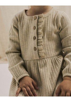 Abito beige a coste con scollo rotondo, dettagli di volant, quattro bottoni in legno e maniche lunghe. La gonna è arricciata in vita.