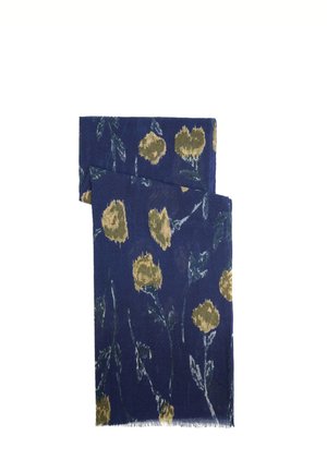 Pañuelo azul con motivo floral amarillo y sutiles hojas grises, doblado con bordes con flecos.