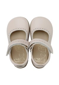 Zapatos Mary Jane de suave cuero beige, con lados perforados, correas ajustables con cierre de gancho y bucle, y interior acolchado.