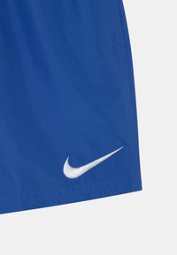 Zila sporta šorti, izgatavoti no viegla auduma, ar baltu izšuvumu Nike logo apakšējā labajā malā. Gluda tekstūra, standarta izmērs.
