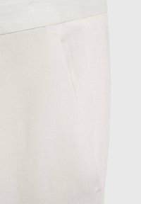 Light beige linen trousers featuring a smooth texture, mid-rise waistband, and side pockets. Simple, clean design with no visible patterns.