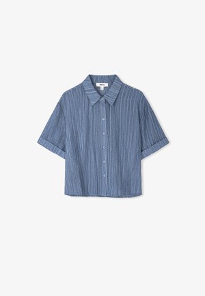 Camicia corta a maniche corte di colore azzurro chiaro con strisce verticali. Dotata di chiusura a bottoni sul davanti e colletto classico. Tessuto morbido e testurizzato.