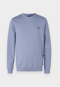 Ljusblå sweatshirt i mjukt tyg. Har V-ringning, ribbade mudd och en liten gul broderad logotyp på vänster bröst.