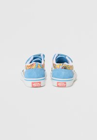 Blå og gul mønstret lave sneakers, laget av suede-materiale, med hvite gummisåler og rosa Vans-logo på hælen.