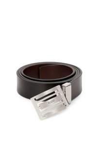 Cinturón de cuero negro con una hebilla rectangular de plata que presenta un diseño geométrico y el logo "Kazar" exhibido de manera prominente.