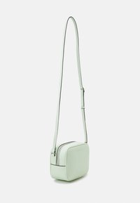 Miętowa torebka na ramię o gładkiej fakturze, prostokątnym kształcie, zapinana na zamek błyskawiczny, z kontrastowymi czarnymi wykończeniami. Regulowany pasek.