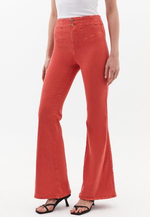 Jeans a zampa d'elefante in un vivace colore corallo, realizzati in denim. Presentano una vita alta con doppio bottone, tasche laterali e una texture liscia.