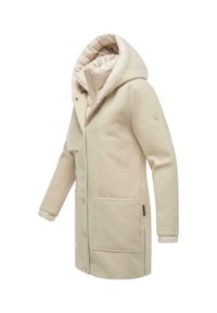 Manteau long beige avec une grande capuche, doté d'une doublure en peluche, de boutons sur le devant et de deux poches avant. Texture lisse avec des accents minimes.