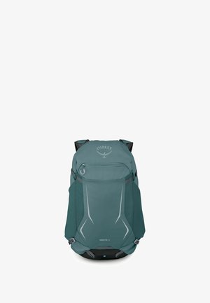 Mochila de senderismo Teal Osprey Hikelite 32 con bolsillo delantero con cremallera, correas laterales y detalles reflectantes sobre fondo blanco.