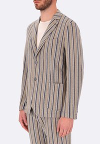 Giacca a righe in beige e blu navy, tessuto strutturato, monopetto con due bottoni, rever a toppa e taschino sul petto.