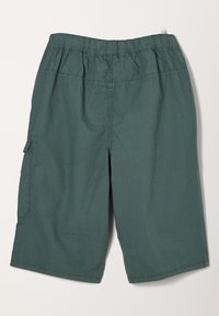 Vihreät, polvenpituisiin, joustovyötäröiset shortsit, joissa on sivutasku ja näkyvä ompelu vaalealla taustalla.