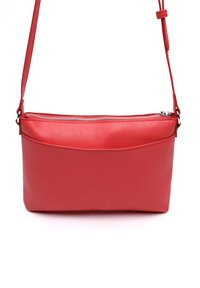 Červená kožená taška cez rameno s textúrovaným povrchom, so zipsom a nastaviteľným rameným popruhom. Má plochý dizajn a minimálne kovové prvky.