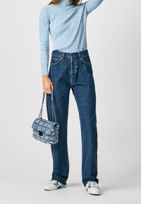Pull à côtes bleu clair, jeans en denim foncé taille haute et sac à main à carreaux bleu clair. Accessoirisé avec des baskets blanches.