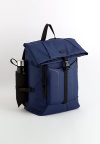 Marinblå ryggsäck med rulltoppsstängning, en framficka med dragkedja och sidoficka för en vattenflaska. Tillverkad av slitstarkt, texturerat tyg.