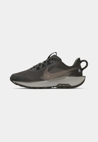 Tumehall Nike Trail jooksujalats, millel on võrgust ülemine osa, suur swooshi logo, pehmendatud krae ja tõmbetab takjapaelal kannas, üksluisel taustal.