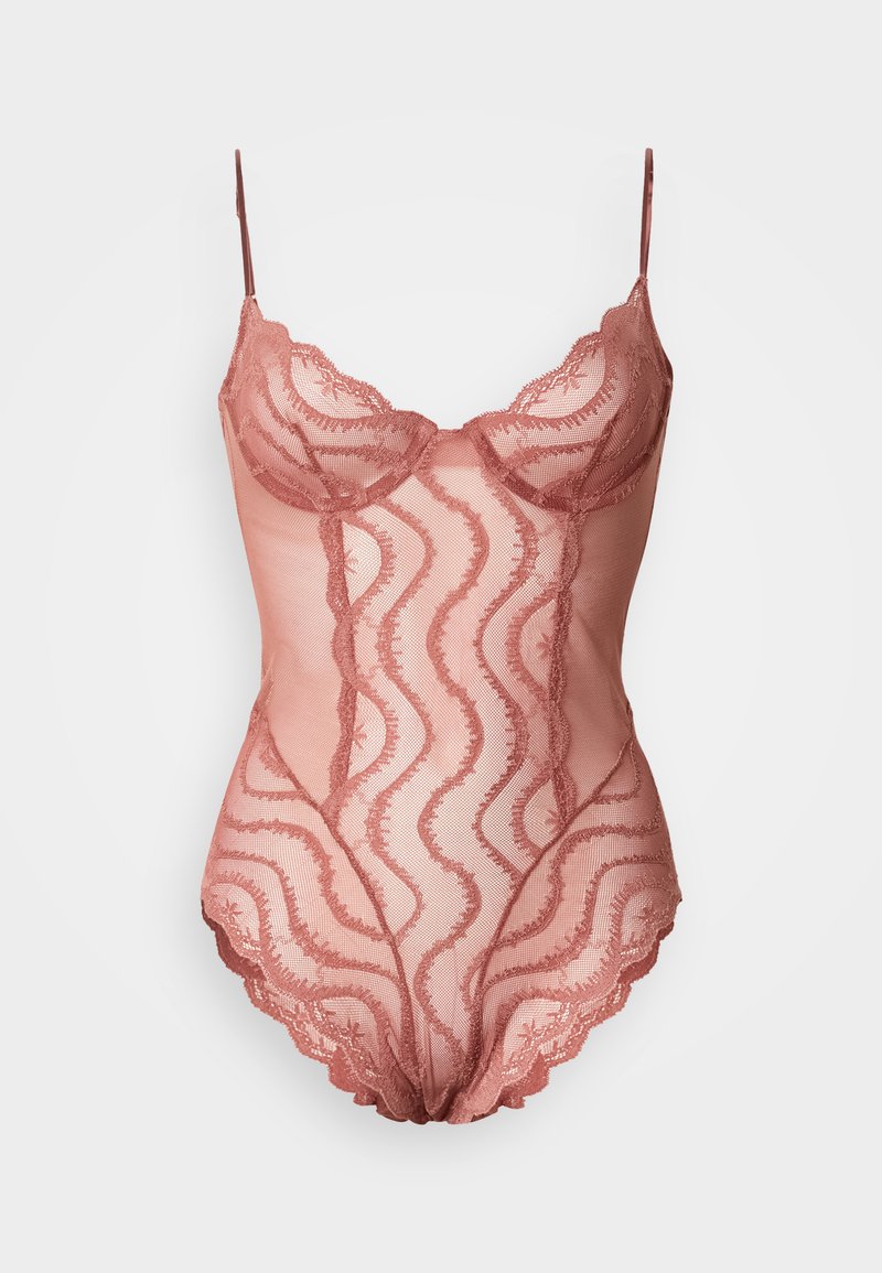 Mežģīņu ķermeņa tērps maigā rozā krāsā ar viļņveida rakstiem, regulējamām lencēm un viļņainām malām. Caurspīdīgs materiāls ar izsmalcinātām detaļām.