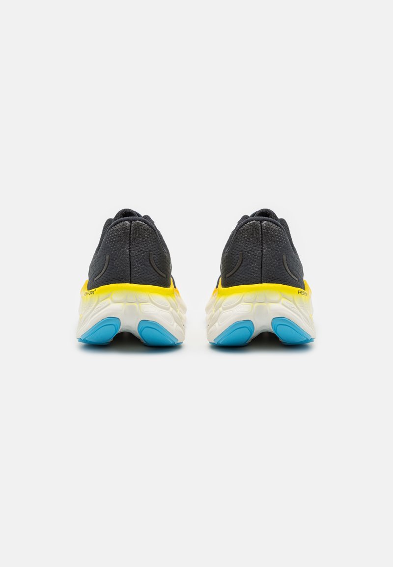 Scarpe da corsa in rete nere con tallone giallo e intersuola bianca. Presentano accenti blu sulla suola. Design imbottito per il massimo comfort.