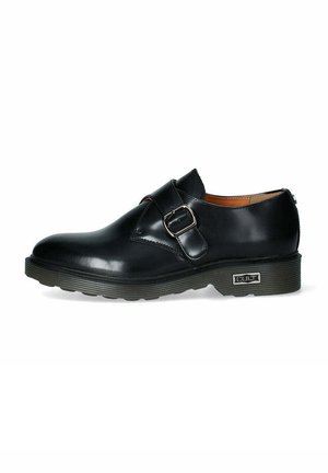 Scarpa in pelle nera con punta arrotondata, una sola fascia e fibbia, e una suola in gomma texturizzata. Presenta un logo discreto sul tallone.