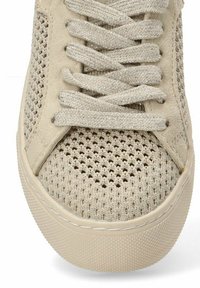 Zapatilla beige con parte superior de malla con detalles texturizados, puntera redonda y cordones planos con acentos metálicos. Suela de goma con patrón.