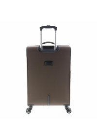 Maleta marrón con exterior duro, asa extensible y cuatro ruedas. Presenta un pequeño logo negro cerca de la base y una textura lisa.