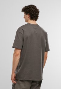 Grå bomulds t-shirt med afslappet pasform, korte ærmer og rund halsudskæring, der har en glat overflade og et enkelt design.