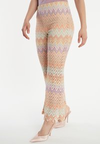 Gepatineerde gebreide leggings met een zigzagpatroon in pastelkleuren, met een flared zoom, gemaakt van een lichtgewicht, gestructureerde stof.
