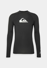 Rash guard negro de manga larga en tejido elástico que presenta un logotipo blanco en el pecho y texto blanco en contraste en la manga.