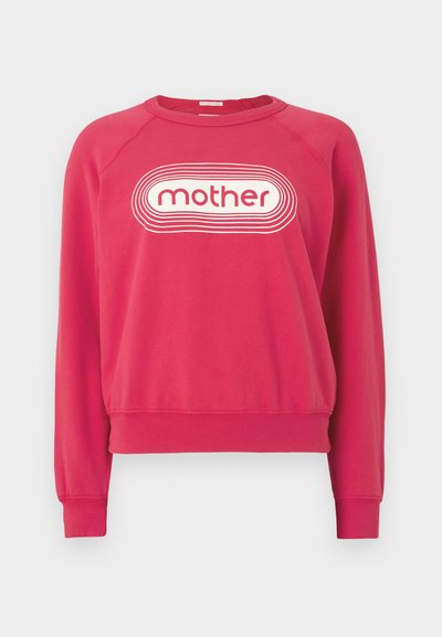 Raudonas džemperis su apvalia iškirpte ir gofruotomis rankogaliais. Priekyje yra balta grafikos logotipas „mother“, apjuostas bangelių kontūrais. Paprastas dizainas.