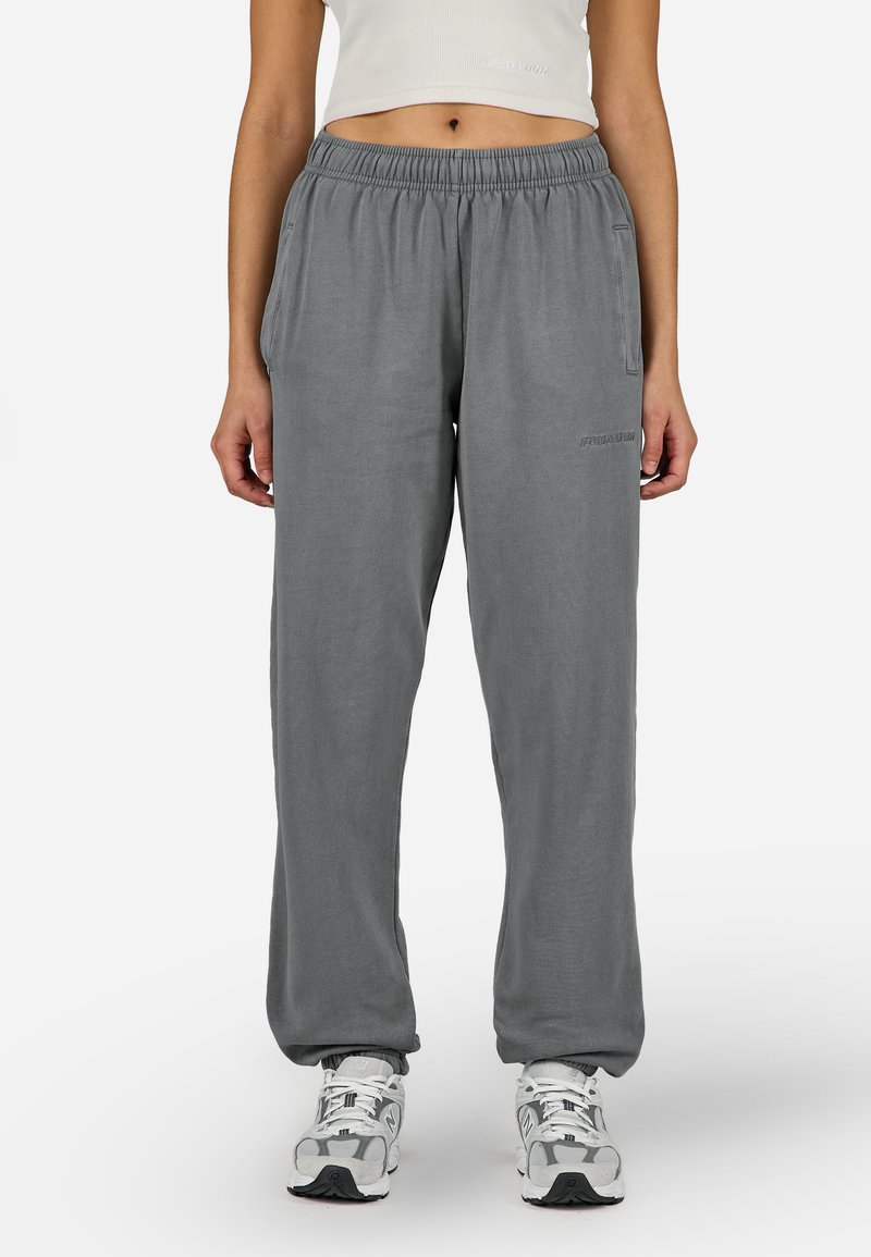 Γκρι φόρμες από μαλακό ύφασμα, με ελαστική μέση, πλαϊνές τσέπες και διακριτική κεντημένη επωνυμία στο πόδι.